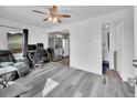 Bright living room with wood floors, chair, desk, and a modern ceiling fan at 244 S Fetzer St, Byers, CO 80103