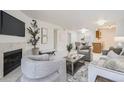 Open-concept living room leading to kitchen and dining area with fireplace and neutral decor at 13093 W Cedar Dr # 121, Lakewood, CO 80228