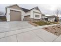 View of the home with a three-car garage and newly landscaped front yard with modern design elements at 1361 Art Dr, Berthoud, CO 80513