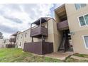 Tan apartment building featuring wood balconies and stairwell in outdoor setting at 9725 E Harvard Ave # 317, Denver, CO 80231