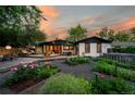 Private backyard oasis with a spacious deck, outdoor seating, a lush garden, and mature trees at 7121 E Arkansas Ave, Denver, CO 80224