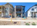 Contemporary three-story home with stone accents, balconies, and a well-maintained front yard at 8633 Middle Fork St, Littleton, CO 80125