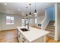 Open concept kitchen with island, stainless steel appliances, and adjacent living area with fireplace at 8633 Middle Fork St, Littleton, CO 80125