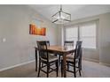 Bright dining area featuring a stylish light fixture and large windows at 20898 E Hamilton Ave, Aurora, CO 80013