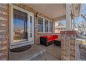 Inviting front porch with comfortable seating and brick accents at 20898 E Hamilton Ave, Aurora, CO 80013