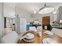 Bright dining area adjacent to kitchen, featuring a round table set for four and modern lighting at 7563 Lamar Ct, Arvada, CO 80003