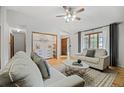 Cozy living room with comfortable seating, light hardwood floors, and plenty of natural light at 7563 Lamar Ct, Arvada, CO 80003