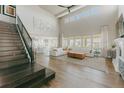 Spacious living room featuring a soaring ceiling, large windows, hardwood floors, and staircase access at 19475 W 94Th Ave, Arvada, CO 80007