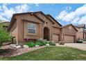 Inviting home with a well-manicured lawn and stone landscaping details at 15616 Soo Line Way, Monument, CO 80132