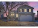 Two-story house with attached garage, illuminated at dusk, showcasing its architectural details at 16641 Martingale Dr, Parker, CO 80134