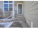 Front entrance with steps leading up to a glass storm door at 16641 Martingale Dr, Parker, CO 80134