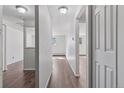 Hallway featuring wood floors, neutral walls, and doorways leading to other rooms in the apartment at 8826 E Florida Ave # G11, Denver, CO 80247