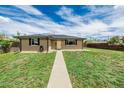 Beautiful single-story brick house with a manicured lawn and a paved walkway at 710 4Th St, Bennett, CO 80102