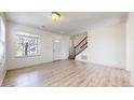 Inviting living room showcasing wood-look flooring, natural light, and easy access to the entry and staircase at 13684 Lilac St, Thornton, CO 80602
