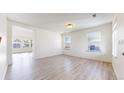 Bright living room with light wood flooring and natural light from multiple windows at 13684 Lilac St, Thornton, CO 80602