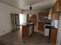 Kitchen with island, light wood cabinets, and tiled floor, undergoing renovation at 5500 Dacono Ct, Byers, CO 80103