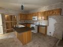 View of a partially renovated kitchen with light wood cabinets and an island at 5500 Dacono Ct, Byers, CO 80103