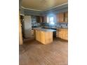 Kitchen featuring wood cabinets, an island, and a window providing natural light at 5500 Dacono Ct, Byers, CO 80103