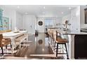 Bright open-concept living space with hardwood floors, a dining table and bar seating at 17616 Bluetrail Ave, Parker, CO 80134