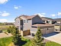 Two-story home featuring neutral siding, a two-car garage, and a well-maintained lawn at 17616 Bluetrail Ave, Parker, CO 80134