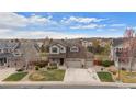 Aerial view of a two-story home with a three-car garage, stone accents, landscaping, and neighborhood view at 7154 E 131St Pl, Thornton, CO 80602