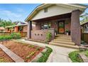 Inviting front porch with brick accents and a landscaped garden, enhancing the home's entrance at 3611 N Vine St, Denver, CO 80205