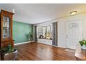 Cozy living room featuring wood floors, a bay window, and a decorative cabinet at 11707 W 65Th Cir, Arvada, CO 80004