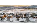 Houses in a neighborhood with snowy yards and mountain views at 9295 Dunraven Loop, Arvada, CO 80007