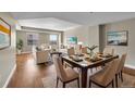 Inviting living room featuring dining area, hardwood floors, large windows, and neutral tones at 300 W 11Th Ave # 8C, Denver, CO 80204