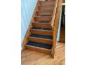 Wooden staircase with dark carpeting on the steps at 4396 Netherland St, Denver, CO 80249