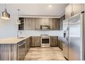 Modern kitchen featuring stainless steel appliances, wood-style cabinets, and quartz countertops at 20 Wilcox St # 316, Castle Rock, CO 80104