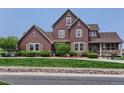 Charming two-story home featuring a manicured lawn, inviting front porch, and classic architectural details at 12745 Uinta St, Brighton, CO 80602