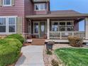 Inviting front porch with a cozy swing, decorative plants, and well-maintained landscaping, offering curb appeal at 12745 Uinta St, Brighton, CO 80602