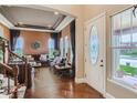 Elegant living room featuring hardwood floors, a coffered ceiling, and a grand staircase, exuding sophistication at 12745 Uinta St, Brighton, CO 80602