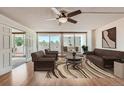 Spacious living room featuring a ceiling fan, wood flooring, and sliding glass doors to a private balcony at 1250 N Humboldt St # 201, Denver, CO 80218