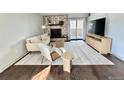 Cozy living room with stone fireplace, comfortable seating, and natural light, complemented by wood floors and modern decor at 7255 E Quincy Ave # 309, Denver, CO 80237