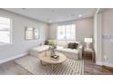 Bright living room featuring a large sectional sofa, decorative pillows, modern art, and a stylish rug at 23731 E 40Th Ave, Aurora, CO 80019