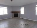 Bright living room features a cozy fireplace, hard surface floors, and large windows for plenty of natural light at 1153 Elbridge Dr, Elizabeth, CO 80107