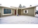 A cozy and quaint snow-covered front porch with a modern door and unique decor at 4274 S Fundy Way, Aurora, CO 80013