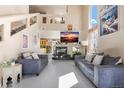 Bright, open living room with a soaring ceiling, fireplace, neutral décor, and ample natural light at 20414 E 55Th Pl, Denver, CO 80249