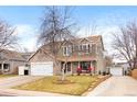 Two-story home featuring a stone facade, attached garage, and inviting porch with a well-manicured front yard at 2924 E 116Th Pl, Thornton, CO 80233