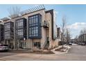 Modern townhome boasts a sleek exterior design with large windows for ample natural light, set on a tree-lined street at 6946 W Alaska Dr, Lakewood, CO 80226