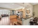 Modern kitchen with stainless steel appliances, granite countertops, and open access to the living area at 6946 W Alaska Dr, Lakewood, CO 80226