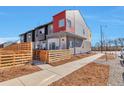 Modern townhome with a unique exterior, privacy fence and side walk on a sunny day at 15295 W 68Th Pl, Arvada, CO 80007