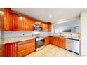 Well-lit kitchen with stainless steel appliances, granite countertops, and tile flooring at 7270 Marmot Ridge Pl, Littleton, CO 80125