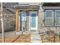 Modern front entrance with a white door and wood accents at 6025 Ames St # A, Arvada, CO 80003