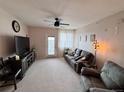 Living room features neutral carpet, a ceiling fan, and access to a balcony at 2675 S Danube Way # 302, Aurora, CO 80013