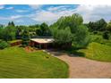 Sprawling property featuring mature trees, well-manicured lawn, and a charming brick home with covered patio at 1016 Stearns Ave, Boulder, CO 80303