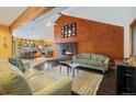 Inviting living room with a modern fireplace, high ceilings, exposed beams, and open access to kitchen at 30444 Ruby Ranch Rd, Evergreen, CO 80439