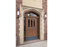 Beautiful exterior front door featuring an arched entryway, decorative stone accents, and vintage lighting at 3132 E 17Th Ave # B, Denver, CO 80206